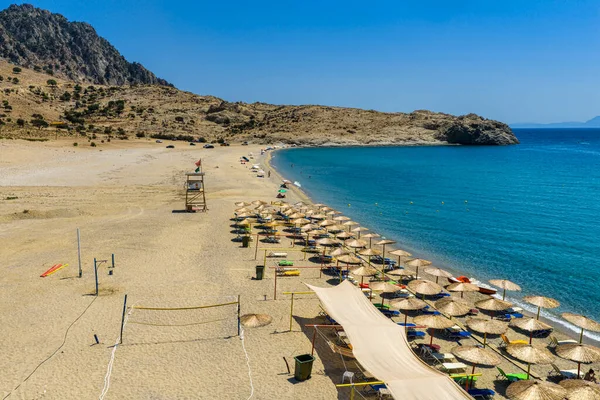 Samothraki, Yunanistan Altın kum, turkuaz deniz, kayalık tepeler ve dağınık şemsiyeleriyle Pachia Ammos Plajı 'nın havadan görünüşü