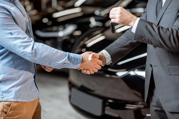 Apretón de manos en la sala de exposición del coche — Foto de Stock