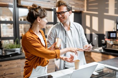 Erkek ve kadın kafe veya küçük dükkanlarda iş yönetiyor.