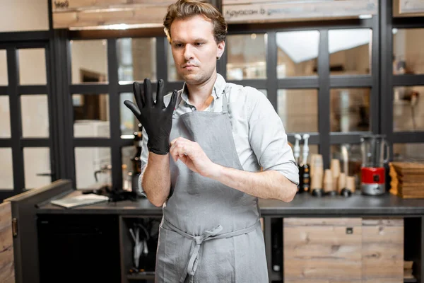 Verkoper draagt handschoenen in het café — Stockfoto