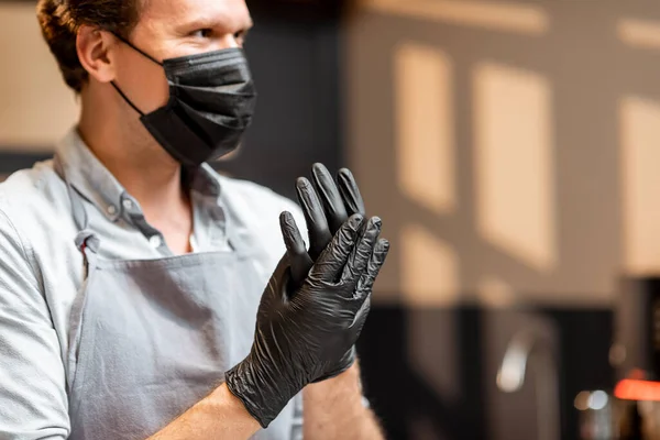 Verkoper desinfecteert handen in een winkel of café — Stockfoto