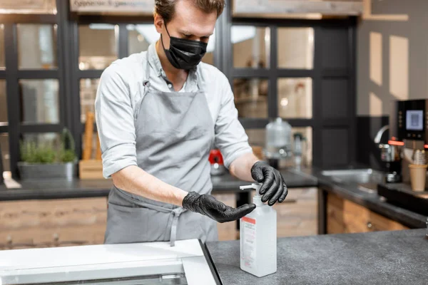 Verkoper in beschermende kleding in het café tijdens een pandemie — Stockfoto