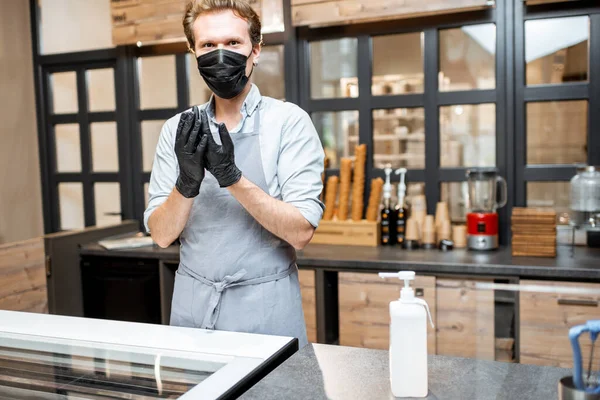 Salesman in protective wear in the cafe during a pandemic