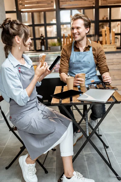 Ett par glada caféarbetare inomhus. — Stockfoto