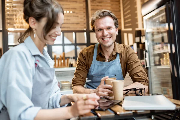 Ett par glada caféarbetare inomhus. — Stockfoto