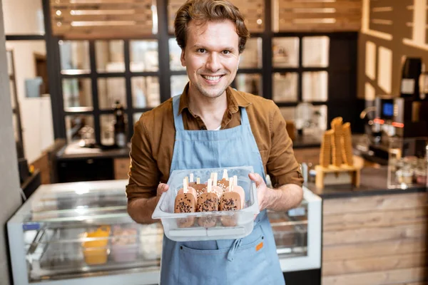 Venditore con gelato al cioccolato su un bastone nel negozio — Foto Stock