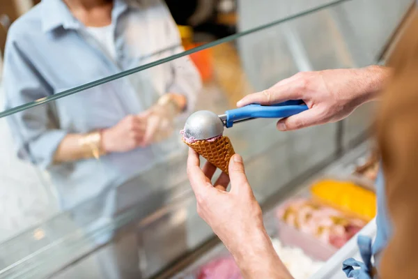 Мужчина продает мороженое молодой женщине — стоковое фото