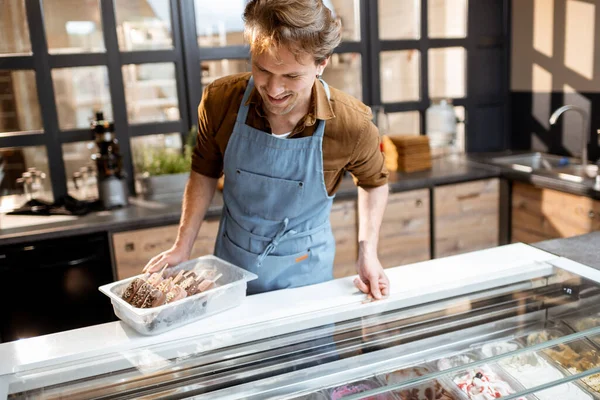 Продавец подмигивает в магазине мороженого — стоковое фото