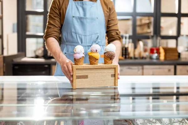 Vendedor con deliciosos helados en la tienda — Foto de Stock