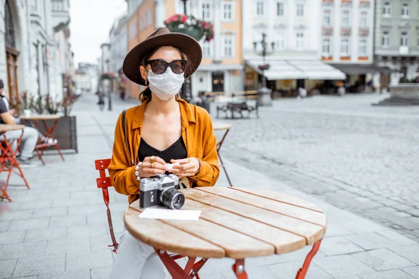 Жінка в масці для захисту обличчя в кафе на відкритому повітрі — стокове фото