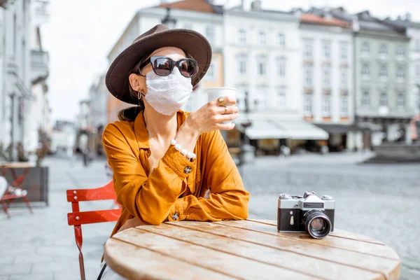 Nainen kasvojen suojaava naamio kahvilassa ulkona — kuvapankkivalokuva