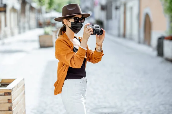 旧市街を旅する顔のマスクの女性 — ストック写真