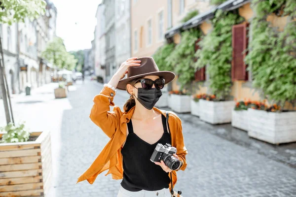 Mujer con máscara facial viajando por la ciudad vieja —  Fotos de Stock