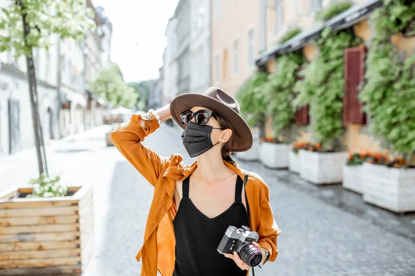 Mujer con máscara facial viajando por la ciudad vieja —  Fotos de Stock