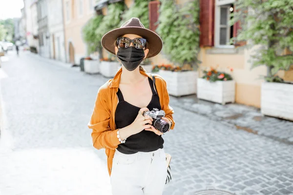 Mulher em máscara facial viajando na cidade velha — Fotografia de Stock