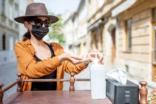 Woman disinfecting her hands outdoors — Stock Photo, Image