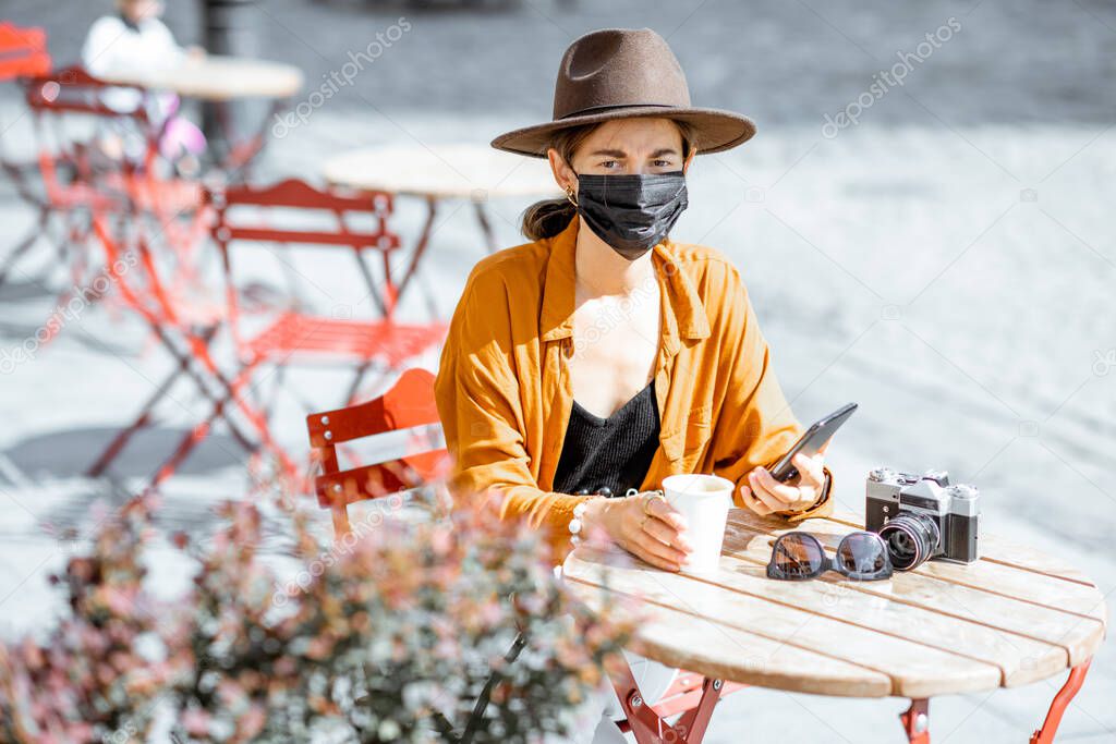 Woman in facial protective mask at the cafe outdoors