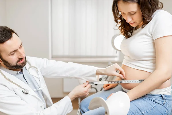 Doktor měří těhotné ženy břicho — Stock fotografie