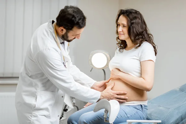 Медицинский массаж брюшной полости беременной женщины во время обследования — стоковое фото