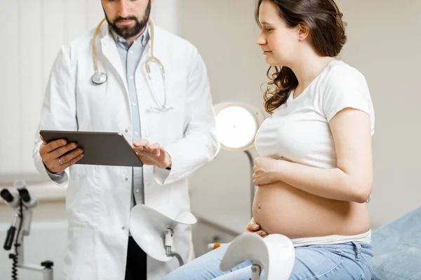 Лікар з вагітною жінкою під час медичної консультації — стокове фото