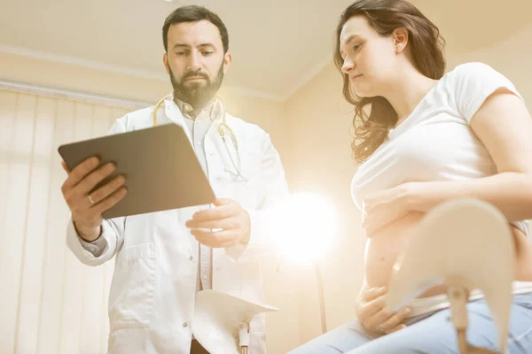 Lékař s těhotnou ženou během lékařské konzultace — Stock fotografie