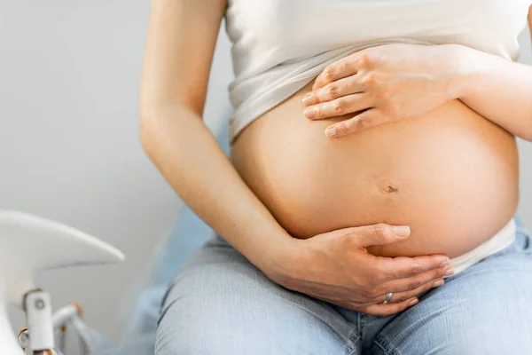 Schwangere umarmt ihren Bauch — Stockfoto