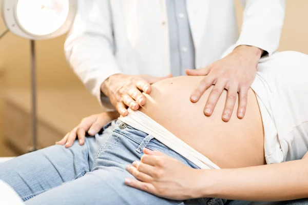 Medizinische Massage des Bauches einer schwangeren Frau während einer Untersuchung — Stockfoto