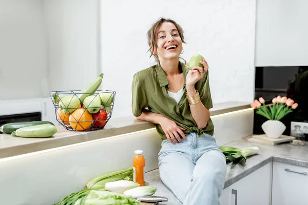 Retrato de uma jovem mulher com comida saudável na cozinha — Fotografia de Stock