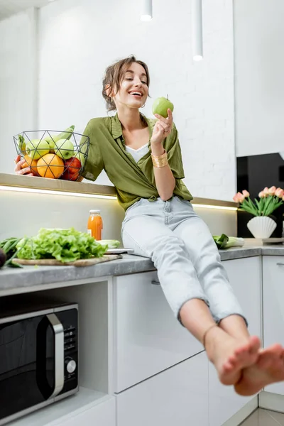 Retrato de uma jovem mulher com comida saudável na cozinha — Fotografia de Stock