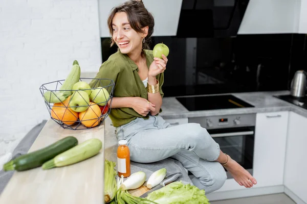 Retrato de una joven con comida sana en la cocina — Foto de Stock