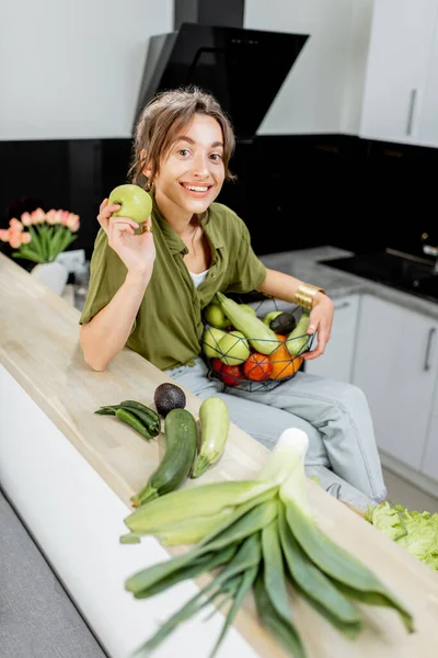 Retrato de uma jovem mulher com comida saudável na cozinha — Fotografia de Stock