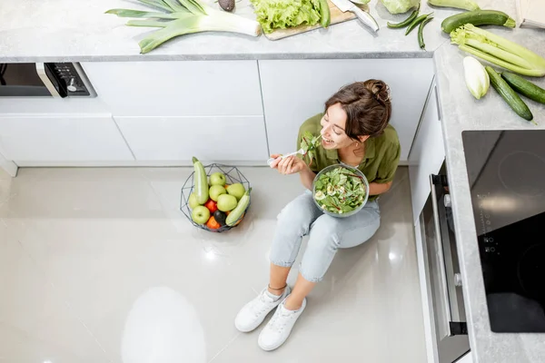 Жінка їсть здоровий салат на кухні вдома — стокове фото