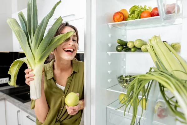 Mulher com ingredientes alimentares saudáveis na cozinha — Fotografia de Stock
