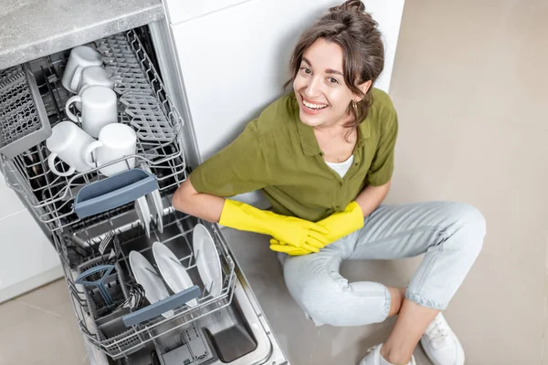 Hausfrau in der Nähe der Spülmaschine zu Hause — Stockfoto