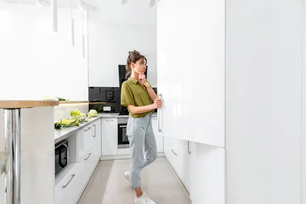 Женщина готовит на белой кухне — стоковое фото