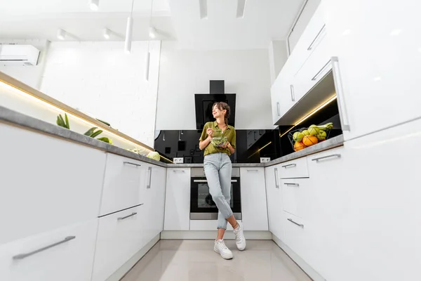 Mulher com comida saudável na cozinha moderna — Fotografia de Stock