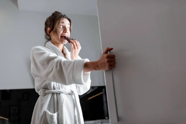 Mujer hambrienta cerca de la nevera en la cocina por la noche — Foto de Stock