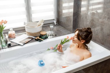 Rahatlamış kadın banyo yapıyor.