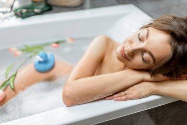 Rahatlamış kadın banyo yapıyor.