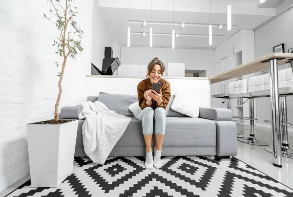 Mujer con teléfono en casa —  Fotos de Stock