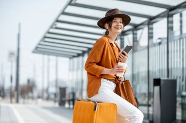 Nakliye durağında bagajı olan genç bir bayan yolcu.