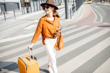 Şehir caddesinde bavullu bir kadın.