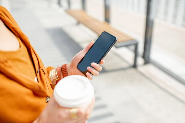 Donna con tazza di caffè e telefono all'aperto — Foto Stock