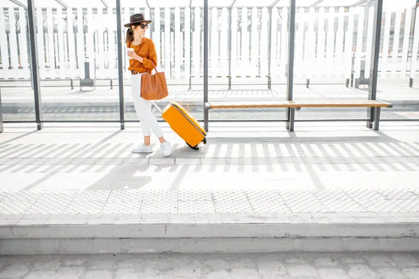 Junge Reisende mit Koffer an der Haltestelle — Stockfoto