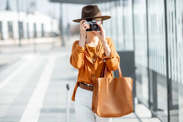 Młoda kobieta podróżuje z aparatem fotograficznym w nowoczesnym mieście — Zdjęcie stockowe