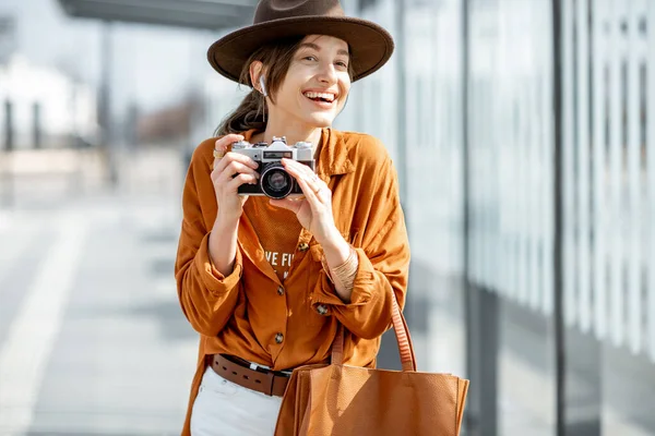 Mujer joven viajando con cámara fotográfica en la ciudad moderna —  Fotos de Stock