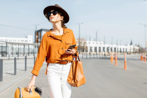 Donna con una valigia sulla strada della città — Foto Stock