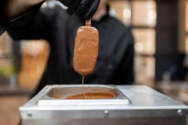 Chef plonge la crème glacée dans le chocolat chaud fondu — Photo