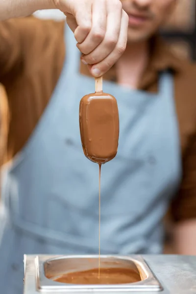 Продавец погружает мороженое в горячий расплавленный шоколад — стоковое фото