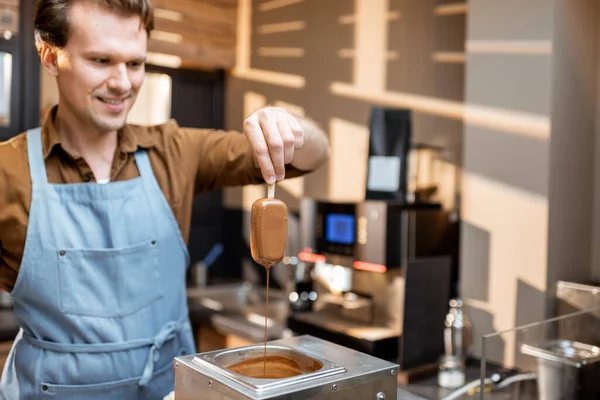 Venditore immerge il gelato nella cioccolata calda fusa — Foto Stock